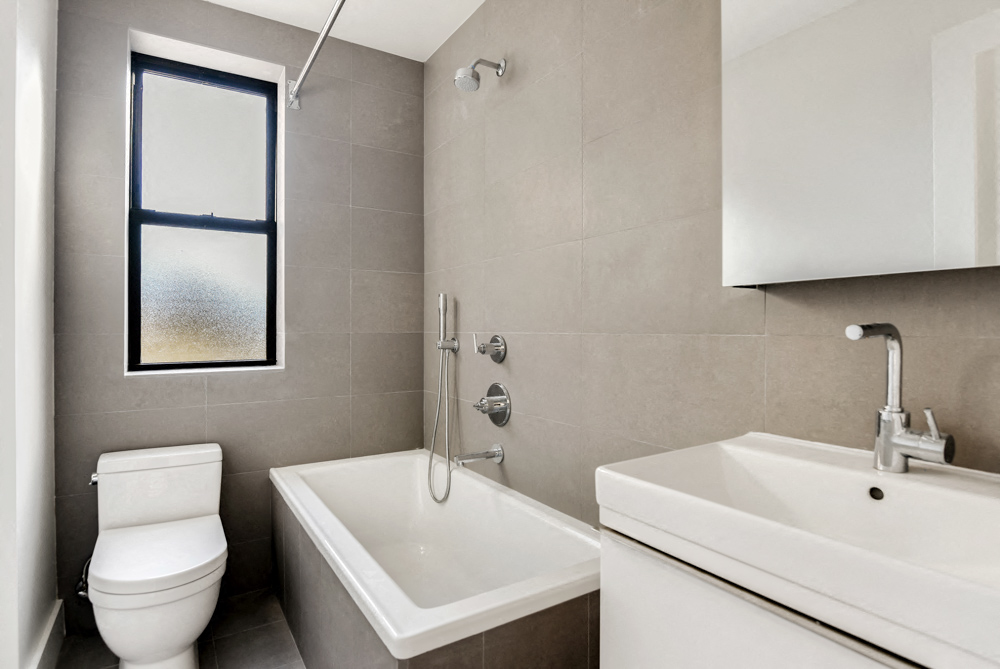 a bathroom with a sink toilet and a window